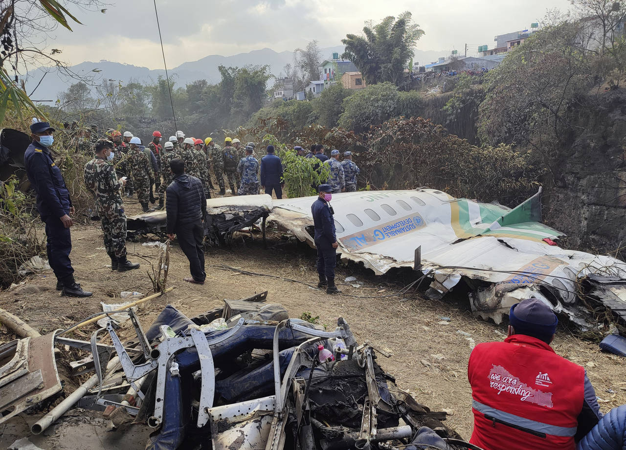 Rescuers stand by wreckage of a passenger plane that crashed in Pokhara, Nepal, Monday, Jan 16, 202...