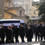 
              Prince Philippos, left, Prince Pavlos, center, and Prince Pavlos, right, sons of former king of Greece Constantine II walk behind their father coffin as they arrive at the Metropolitan cathedral for his funeral in Athens, Monday, Jan. 16, 2023. Constantine died in a hospital late Tuesday at the age of 82 as Greece's monarchy was definitively abolished in a referendum in December 1974. (AP Photo/Petros Giannakouris)
            