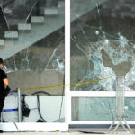 
              An forensic investigator stands outside the Brazilian Supreme Court building in front of windows damaged by supporters of Brazil's former President Jair Bolsonaro, in Brasilia, Brazil, Tuesday, Jan. 10, 2023. Bolsonaro supporters who refuse to accept his election defeat stormed Congress, the Supreme Court and presidential palace Sunday, a week after the inauguration of his leftist rival, President Luiz Inacio Lula da Silva. (AP Photo/Eraldo Peres)
            