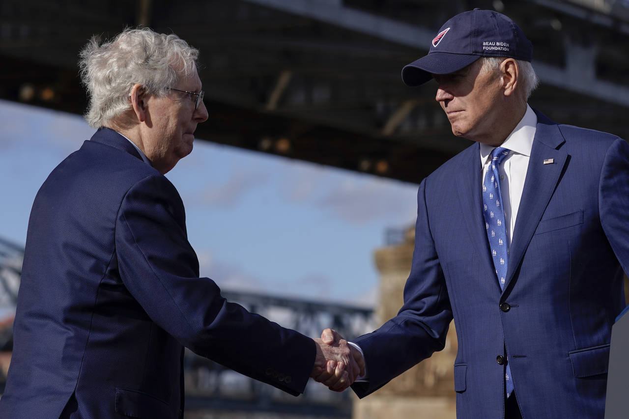 President Joe Biden shakes hands with Senate Minority Leader Mitch McConnell of Ky., after speaking...