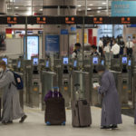 
              Nuns wearing face masks with their luggage arrive at the immigration counters of the departure hall at Lok Ma Chau station following the reopening of crossing border with mainland China, in Hong Kong, Sunday, Jan. 8, 2023. Travelers crossing between Hong Kong and mainland China, however, are still required to show a negative COVID-19 test taken within the last 48 hours, a measure China has protested when imposed by other countries. (AP Photo/Bertha Wang)
            