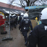 
              Police officers enter a camp of climate protestors at the village Luetzerath near Erkelenz, Germany, Wednesday, Jan. 11, 2023. Police have entered the condemned village in, launching an effort to evict activists holed up at the site in an effort to prevent its demolition to make way for the expansion of a coal mine.  (Rolf Vennenbernd/dpa via AP)
            