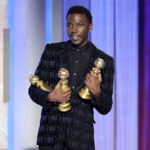 
              This image released by NBC shows host Jerrod Carmichael holding three Golden Globes during the 80th Annual Golden Globe Awards at the Beverly Hilton Hotel on Tuesday, Jan. 10, 2023, in Beverly Hills, Calif. (Rich Polk/NBC via AP)
            