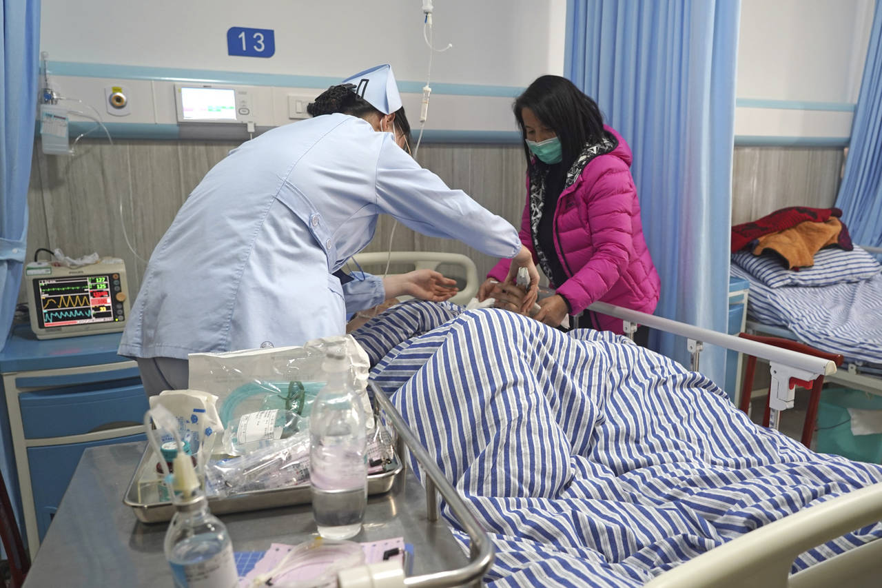In this photo released by Xinhua News Agency, a wounded person receives medical treatment at a hosp...
