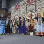 
              Members of the Navajo Nation Council wave to the audience after they were sworn into office Tuesday, Jan. 10, 2023 at the Bee Holdzil Fighting Scouts Event Center in Fort Defiance, Ariz. The council will have a record nine women among the 24 members. (AP Photo/Felicia Fonseca)
            