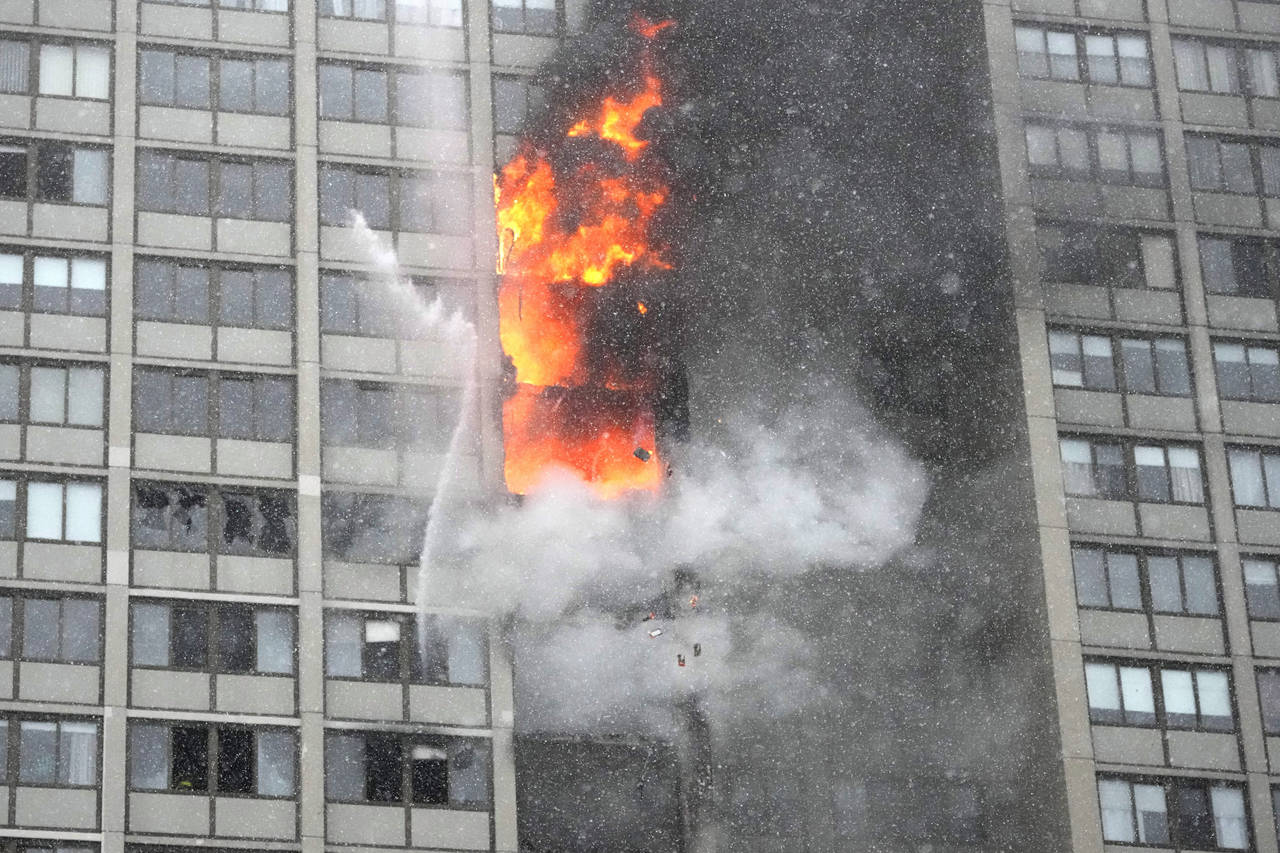 Flames leap skyward out of the Harper Square cooperative residential building in the Kenwood neighb...