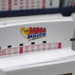 
              FILE - A display holds Mega Million lottery ticket wagering cards at Ted's State Line Mobil station, Thursday, Jan. 5, 2023, in Methuen, Mass. An estimated $1.1 billion Mega Millions jackpot drawing Tuesday, Jan. 10, 2023, has people lined up at convenience stores nationwide to buy tickets in longshot hopes of winning a massive prize, but shop and gas station owners selling the tickets also have a chance at a big-figure bonus. (AP Photo/Charles Krupa, File)
            