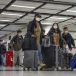 
              Travelers wearing face masks with their luggage head to the immigration counter at the departure hall at Lok Ma Chau station following the reopening of crossing border with mainland China, in Hong Kong, Sunday, Jan. 8, 2023. Travelers crossing between Hong Kong and mainland China, however, are still required to show a negative COVID-19 test taken within the last 48 hours, a measure China has protested when imposed by other countries. (AP Photo/Bertha Wang)
            