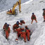 
              In this photo released by Xinhua News Agency, Rescuers search for survivors following an avalanche in Nyingchi, southwest China's Tibet Autonomous Region on Friday, Jan. 20, 2023. More bodies were found Friday following an avalanche that buried vehicles outside a highway tunnel in Tibet, raising the death toll more than a dozen with several people still missing. (Sun Fei/Xinhua via AP)
            