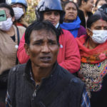 
              People watch rescuers work at the site of plane crash in Pokhara, Nepal, Sunday, Jan. 15, 2023. A plane making a 27-minute flight to a Nepal tourist town crashed into a gorge Sunday while attempting to land at a newly opened airport, killing at least 68 of the 72 people aboard. At least one witness reported hearing cries for help from within the fiery wreck, the country’s deadliest airplane accident in three decades. (AP Photo/Yunish Gurung)
            