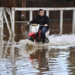 
              Devan Beard, 13, of Brentwood, Calif., rides his off-road motorcycle around his flooded home on Bixler Road in Brentwood, Calif., on Monday, Jan. 16, 2023. The last in a three-week series of major winter storms is churning through California. (Jose Carlos Fajardo/Bay Area News Group via AP)
            