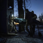 
              Ukrainian military medics carry a body of their killed comrade into a morgue in Donetsk region, Ukraine, Monday, Jan. 9, 2023. (AP Photo/Evgeniy Maloletka)
            