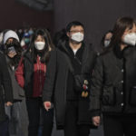 
              FILE - People wearing face masks walk along a street in Beijing, Friday, Jan. 6, 2023. China has suspended or closed the social media accounts of more than 1,000 critics of the government’s policies on the COVID-19 outbreak, as the country moves to further open up. (AP Photo/Andy Wong)
            