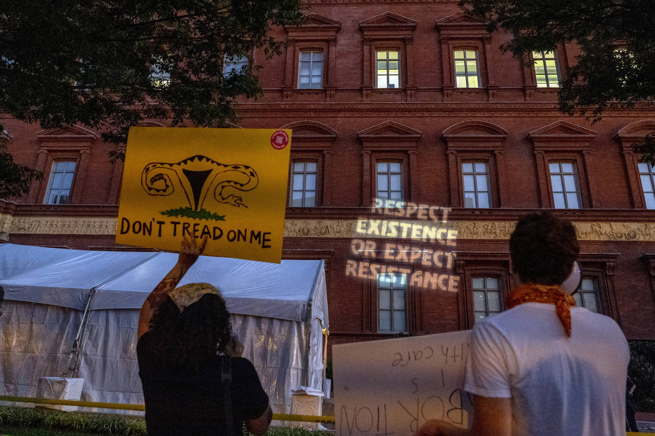 FILE - Abortion-rights protesters project messages to a building during an event sponsored by Susan...