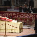 
              The body of late Pope Emeritus Benedict XVI laids out in state as father Georg Gaenswein stands on the right inside St. Peter's Basilica at The Vatican, Monday, Jan. 2, 2023. Benedict XVI, the German theologian who will be remembered as the first pope in 600 years to resign, has died, the Vatican announced Saturday. He was 95. (AP Photo/Andrew Medichini)
            