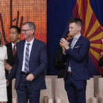 
              Arizona Democratic Gov. Katie Hobbs, left, pauses on stage as she stands next to husband Patrick Goodman, second from left, son Sam and daughter Hannah, right, after giving her inaugural address at the state Capitol in Phoenix, Thursday, Jan. 5, 2023. (AP Photo/Ross D. Franklin)
            