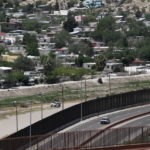 
              FILE - A residential neighborhood of Juarez, Mexico, and U.S. Border Patrol vehicles on both sides of a border fence as seen from El Paso Texas, April 22, 2020. President Joe Biden is heading to the U.S.-Mexico border on Sunday, Jan. 8, 2023, for his first visit as president. Biden will stop in El Paso, currently the biggest corridor for illegal crossings. (AP Photo/Cedar Attanasio, File)
            