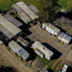 
              In this photo taken by a drone, a cluster of mobile homes is seen at the California Terra Garden, formerly Mountain Mushroom Farm in Half Moon Bay, Calif., Thursday, Jan. 26, 2023. A farmworker accused of killing seven people in shootings at two Northern California mushroom farms, including this one, has been charged with seven counts of murder. Prosecutors filed the charges Wednesday. A court appearance for 66-year-old Chunli Zhao was postponed until Feb. 16. (Santiago Mejia/San Francisco Chronicle via AP)
            