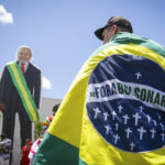 
              A man carries a flag reading in Portuguese "Bolsonaro Out¨ prior to the inauguration of Luiz Inacio Lula da Silva as new president in Brasilia, Brazil, Sunday, Jan. 1, 2023. (AP Photo/Gustavo Moreno)
            