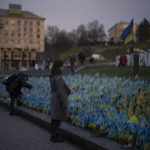 
              A woman stops to look at Ukrainian flags placed in memory of those killed during the war, near Maidan Square in central Kyiv, Ukraine, Friday, Jan. 20, 2023. (AP Photo/Daniel Cole)
            