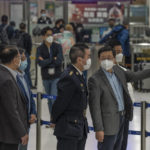 
              Hong Kong Chief Executive John Lee, right, speaks to an officer as he inspects Lok Ma Chau station following the reopening of crossing border with mainland China, in Hong Kong, Sunday, Jan. 8, 2023. Travelers crossing between Hong Kong and mainland China, however, are still required to show a negative COVID-19 test taken within the last 48 hours, a measure China has protested when imposed by other countries. (AP Photo/Bertha Wang)
            