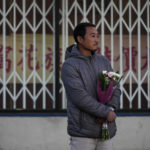 
              Hunter Zhao, 41, holds flowers to honor the victims killed in Saturday's ballroom dance studio shooting in Monterey Park, Calif., Sunday, Jan. 22, 2023. A gunman killed multiple people at the Star Ballroom Dance Studio late Saturday amid Lunar New Years celebrations in the predominantly Asian American community. (AP Photo/Jae C. Hong)
            