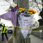 
              FILE - Flowers are secured to a pole as a memorial to Karon Blake, 13, on the corner of Quincy Street NE and Michigan Avenue NE in the Brookland neighborhood of Washington,  Jan. 10, 2023. The note reads, "Karon we will love and miss you dearly."   Jason Lewis, a longtime Parks and Recreation Department employee, turned himself in Tuesday morning to face charges of second-degree murder while armed. Lewis shot middle schooler Karon Blake on Jan. 7, around 4 a.m.  (AP Photo/Carolyn Kaster, File)
            