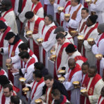 
              Priests prepare for the holy communion during the funeral mass for late Pope Emeritus Benedict XVI in St. Peter's Square at the Vatican, Thursday, Jan. 5, 2023. Benedict died at 95 on Dec. 31 in the monastery on the Vatican grounds where he had spent nearly all of his decade in retirement. (AP Photo/Ben Curtis)
            