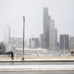 
              A pedestrian walks along Roosevelt Road in the West Loop as the Chicago skyline is seen in the background, Friday, Dec. 23, 2022. The Arctic blast brought wind chills down to as low as 40 degrees Friday.  (Pat Nabong/Chicago Sun-Times via AP)
            