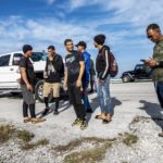 
              A group of Cuban migrants stand in the sun on the side of U.S. in the Middle Keys island of Duck Key, Fla., Monday Jan. 2, 2023. (Pedro Portal/Miami Herald via AP)
            