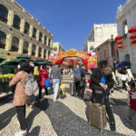 
              Travelers from mainland China walk around Senado Square, a tourist destination in Macao, Wednesday, Jan. 18, 2022. A hoped for boom in Chinese tourism over next week's Lunar New Year holidays looks set to be more of a blip as most travelers avoid traveling overseas, if at all. (AP Photo/Kanis Leung)
            