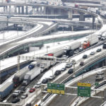 
              FILE - Tractor trailers and other vehicles are at a stand still as they exit the Brent Spence Bridge near downtown Cincinnati heading toward Ft. Washington Way, Feb. 9, 2021. According to a recent announcement by Kentucky and Ohio they will receive more than $1.63 billion in federal grants to help build a new Ohio River bridge near Cincinnati and improve the existing overloaded span there, a heavily used freight route linking the Midwest and the South. (Cara Owsley/The Cincinnati Enquirer via AP, File)
            