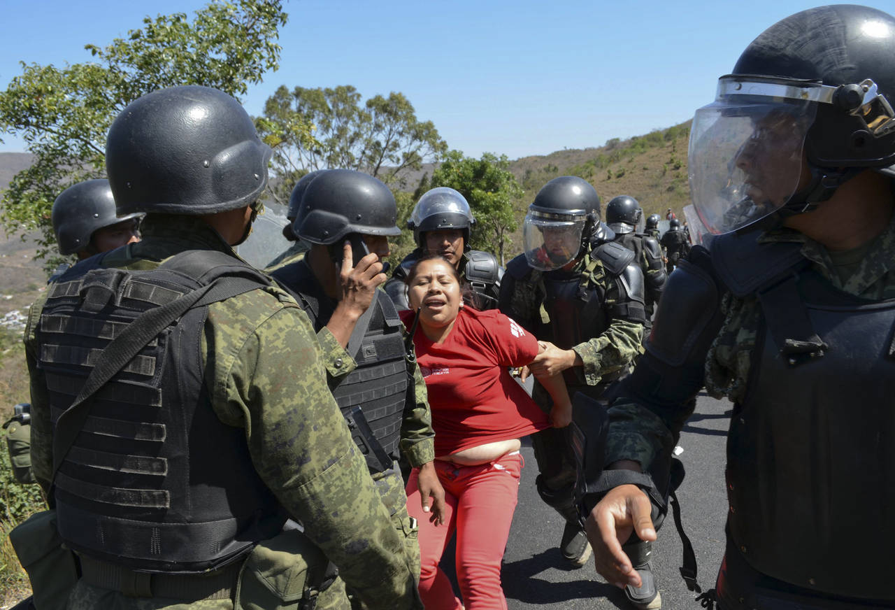 FILE - A woman is detained by Mexican army military police in a neighborhood in the city of Chilpan...