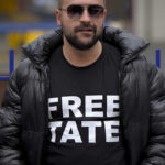 
              A man stands outside the Court of Appeal during the hearings for Andrew Tate, his brother Tristan and two other suspects in Bucharest, Romania, Tuesday, Jan.10, 2023. Andrew Tate, a divisive social media personality and former professional kickboxer, was detained last month in Romania on charges of human trafficking and rape, and later arrested for 30 days after a court decision. (AP Photo/Alexandru Dobre)
            