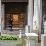
              A woman takes pictures of the "triclinium", or dining room, called Hall of Pentheus, part of the Ancient Roman Domus Vettiorum, House of Vettii, in the Pompeii Archeological Park, near Naples, southern Italy, Wednesday, Dec. 14, 2022. One of Pompeii's most famous and richest domus, which contains exceptional works of art and tells the story of the social ascent of two former slaves, is opening its doors to visitors Wednesday, Jan. 11, 2023 after 20 years of restoration. (AP Photo/Andrew Medichini)
            