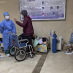 
              Medical workers talk to a woman as an elderly woman receives medical treatment in the hallway of the emergency ward in Beijing, Thursday, Jan. 19, 2023. China on Thursday accused "some Western media" of bias, smears and political manipulation in their coverage of China's abrupt ending of its strict "zero-COVID" policy, as it issued a vigorous defense of actions taken to prepare for the change of strategy. (AP Photo/Andy Wong)
            