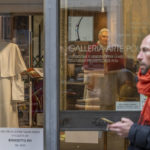
              A pedestrian walks by a painting of Pope Emeritus Benedict XVI and one of the last cassocks worn by him before his resignation in 2013, according to the director of the Progetto Arte Poli gallery where it is displayed, near the Vatican, Tuesday, Jan. 3, 2023. The Vatican announced that Pope Benedict died on Dec. 31, 2022, aged 95, and that his funeral will be held on Thursday, Jan. 5, 2023. (AP Photo/Ben Curtis)
            