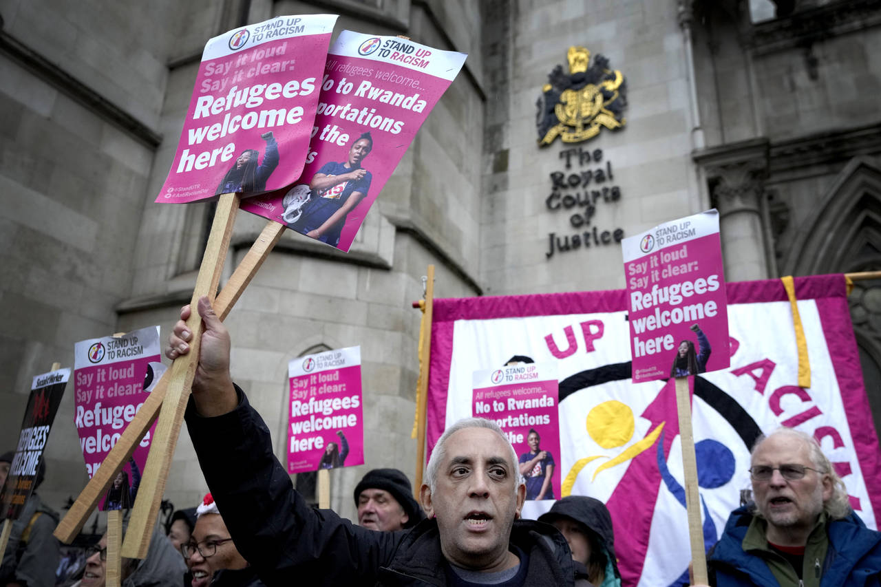 FILE - Stand Up To Racism campaigners hold banners outside the High Court in London, Monday, Dec. 1...