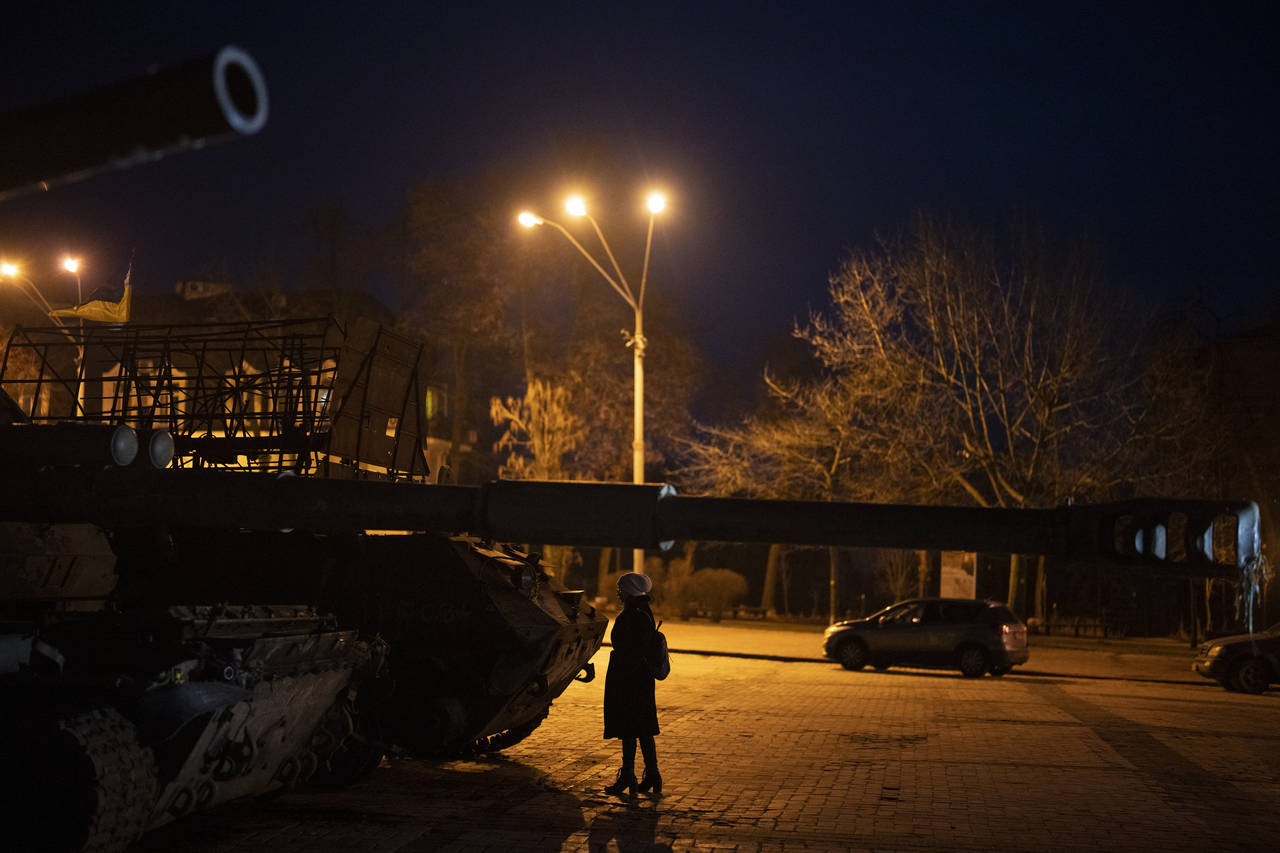 A woman stands in front of a display of destroyed Russian tanks and armoured vehicles in downtown K...