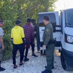 
              CORRECTS YEAR TO 2023 NOT 2022 - A U.S. Border Patrol agent attends to migrants by a van parked on Garden Cove Road in Key Largo, Fla., Tuesday, Jan. 3, 2023. (David Goodhue/Miami Herald via AP)
            