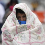 
              FILE - A migrant from Venezuela walks in the cold weather at a makeshift camp on the U.S.-Mexico border in Matamoros, Mexico, Dec. 23, 2022. The Biden administration on Thursday, Jan. 5, said it would immediately begin turning away Cubans, Haitians and Nicaraguans who cross the U.S.-Mexico border illegally, a major expansion of an existing effort to stop Venezuelans attempting to enter the U.S. (AP Photo/Fernando Llano, File)
            