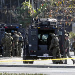 
              SWAT personnel surround a van, not seen, in Torrance Calif., Sunday, Jan. 22, 2023. A mass shooting took place at a dance club following a Lunar New Year celebration, setting off a manhunt for the suspect. (AP Photo/Damian Dovarganes)
            