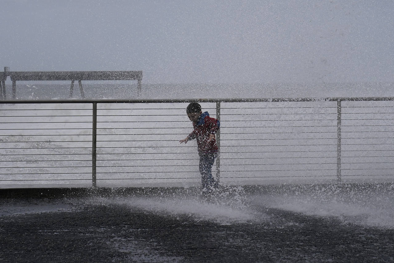 Anthony Tablit, 5, is is soaked as waves crash into a seawall in Pacifica, Calif., Friday, Jan. 6, ...