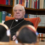 
              German Cardinal Gerhard Mueller pauses during an interview with The Associated Press in his apartment in Rome, Wednesday, Jan. 4, 2023. Benedict gave his fellow German theologian his old job, as prefect of the Vatican’s doctrine office. He entrusted his life’s theological works to Mueller, who has spent nearly two decades organizing them in a 16-volume, 25,000-page opus along the lines of Thomas Aquinas’ Summa Theologica. He gave him his old flat on the top floor of a Vatican apartment building, where he had lived as Cardinal Joseph Ratzinger.  In the foreground, Muller's glasses rest on his desk. (AP Photo/Domenico Stinellis)
            