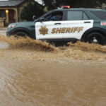 
              A Santa Cruz County Sheriff's deputy patrols in the flooding waters from a storm along College Road near Cutter Drive, on Monday, Jan. 9, 2023, in Watsonville, Calif. (Shmuel Thaler/The Santa Cruz Sentinel via AP)
            
