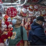 
              Shoppers look at Lunar New Year decorations for sale at a street stall in the Sham Shui Po district in Hong Kong, Wednesday, Jan. 18, 2023. The Year of the Rabbit officially begins on Jan. 22. (AP Photo/Anthony Kwan)
            