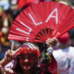 
              A supporters of Luiz Inacio Lula da Silva flashes a victory sign prior to his inauguration as new president in Brasilia, Brazil, Sunday, Jan. 1, 2023. (AP Photo/Silvia Izquierdo)
            