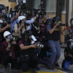
              Journalists cover clashes between police and anti-government protesters in Lima, Peru, Tuesday, Jan. 24, 2023. Protesters are seeking the resignation of President Dina Boluarte, the release from prison of ousted President Pedro Castillo, immediate elections and justice for demonstrators killed in clashes with police. (AP Photo/Martin Mejia)
            