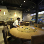 
              A worker cleans a table in an empty seafood restaurant on the popular tourist island of Bali, Indonesia on Wednesday, Jan. 18, 2023. A hoped-for boom in Chinese tourism in Asia over next week's Lunar New Year holidays looks set to be more of a blip as most travelers opt to stay inside China if they go anywhere. (AP Photo/Firdia Lisnawati)
            