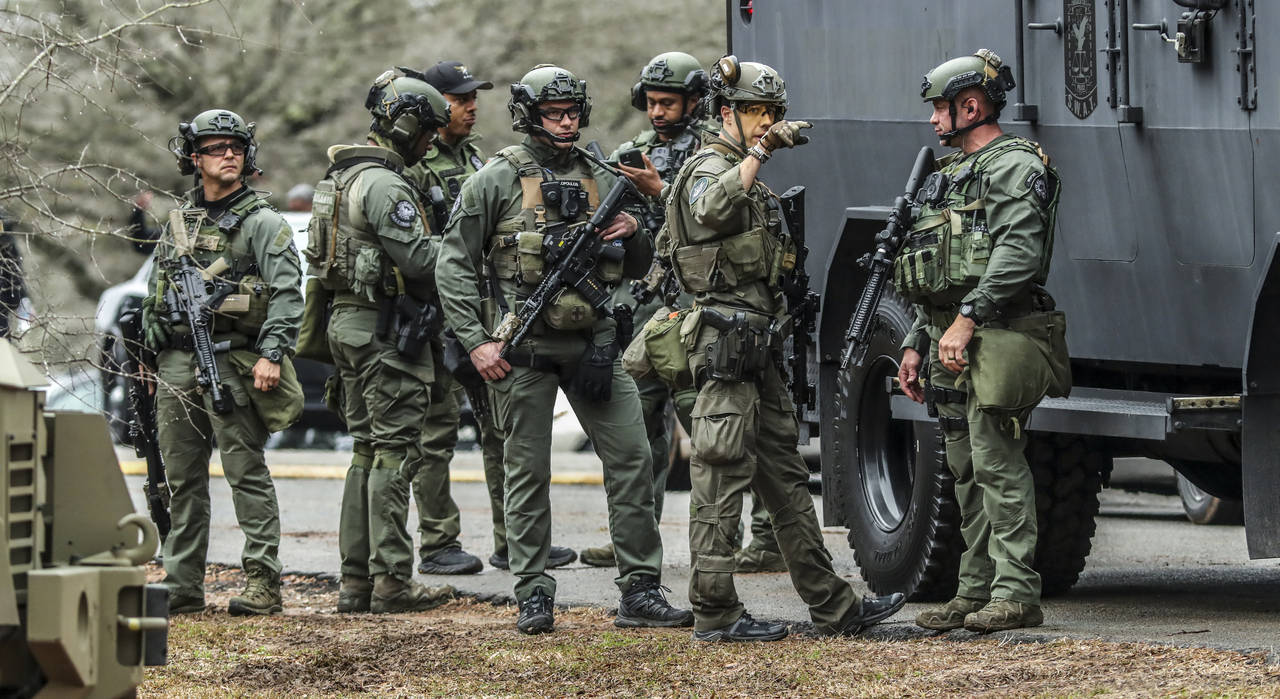 DeKalb, Ga., and Atlanta SWAT members are pictured leaving the Gresham Park command post in Atlanta...